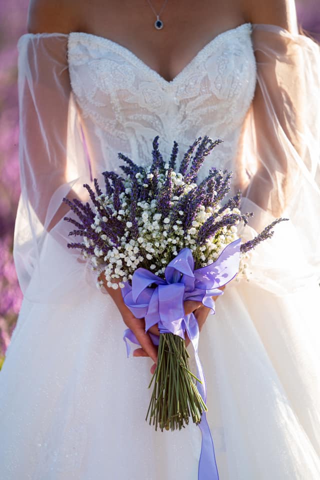 Bride holding a lavender and baby's breath bouquet with a purple ribbon during a wedding by Dubai Proposal Photographer