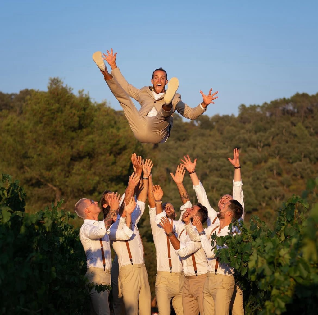 Groom thrown in the air by groomsmen during a joyful wedding celebration photographed by Lillo Dubai wedding photographer 