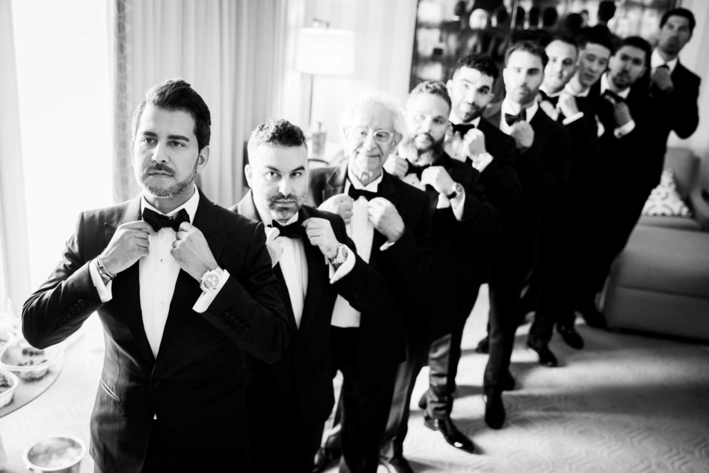Groom and groomsmen preparing in a luxury hotel suite, photographed by a Dubai wedding photographer.