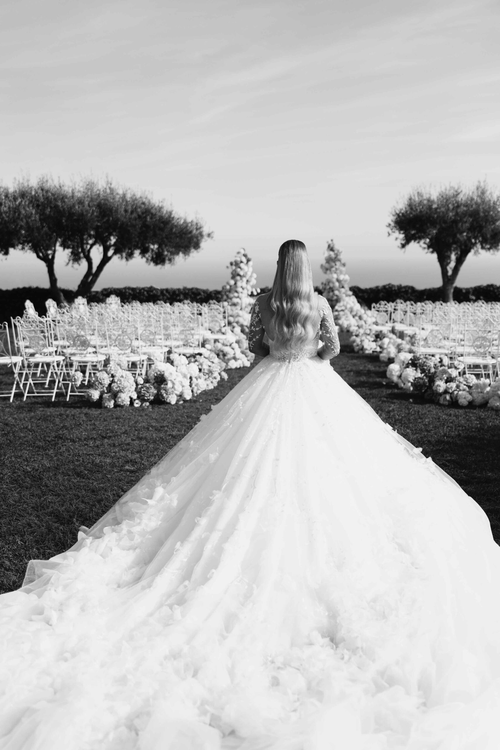 Wedding photographer Dubai capturing a luxury outdoor ceremony with bride walking during golden hour